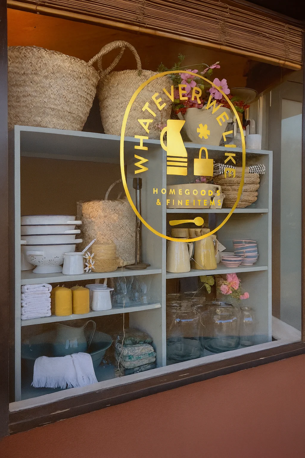 Display of home decor items in a store with 'Whateverwelike' logo.